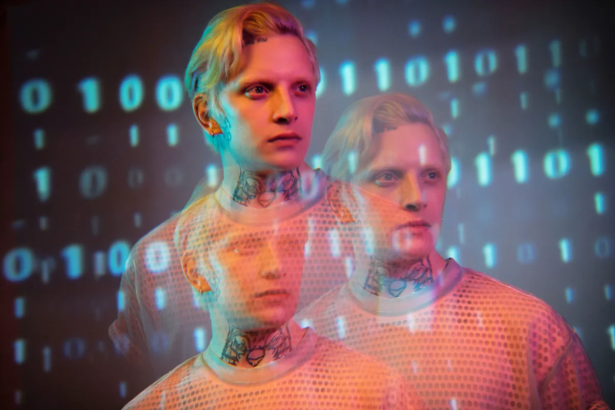 Triple-exposure portrait of a man overlaid with streams of binary code