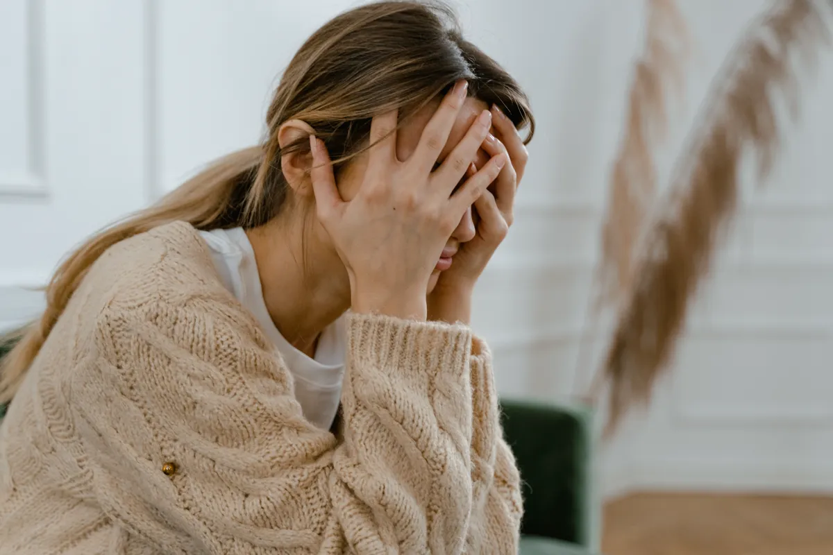 A woman sitting with her face in her hands